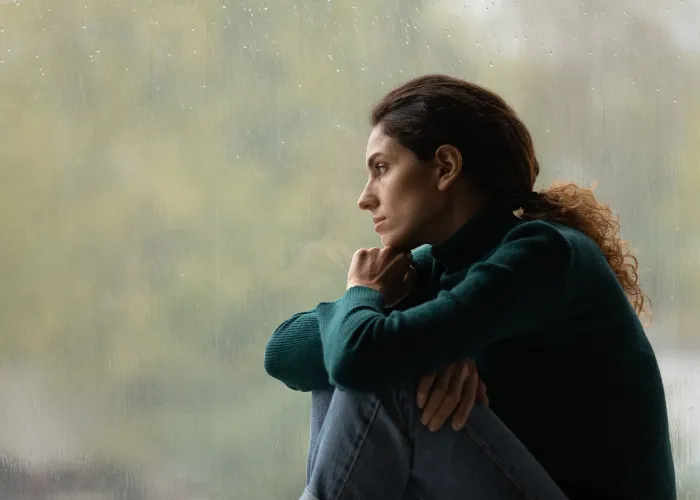 Side view frustrated thoughtful woman looking out rainy window in distance alone, lost in thoughts, upset unhappy young female feeling lonely and depressed, thinking about relationship problems