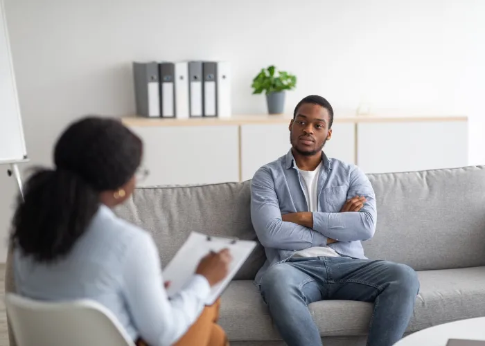 Psychological counselling. Black male patient with depression having session with psychotherapist at office. African American man with PTSD consulting mental health professional at clinic